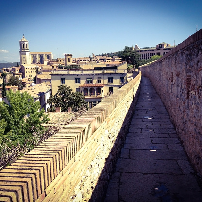 View of part of the medieval city walls walk surrounding old Girona city with the cathedral on the far left