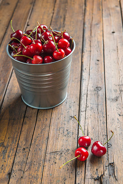 istock Little brass bucket of cherries on a table 498849781