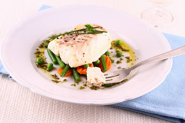 istock Cod fillet on fork, green beans, peas, parsley, olive oil 498850345