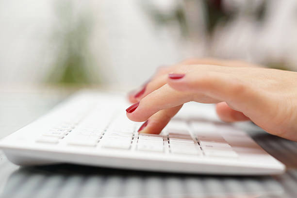istock female fingers typing on white keyboard 498850849