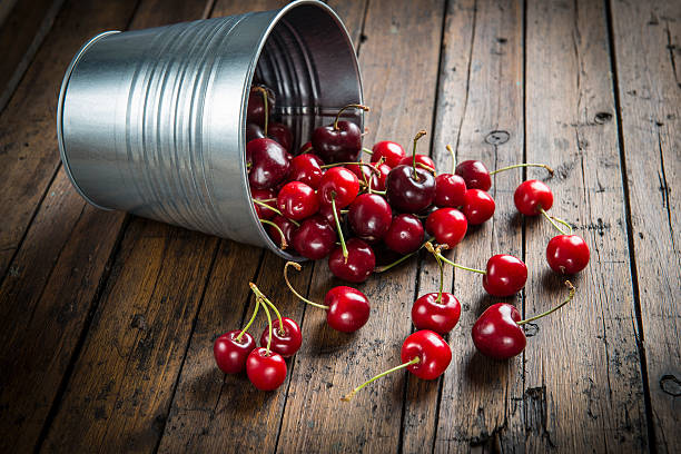 Little brass bucket of cherries on a table