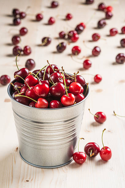 istock Little brass bucket of cherries on a table 498851067