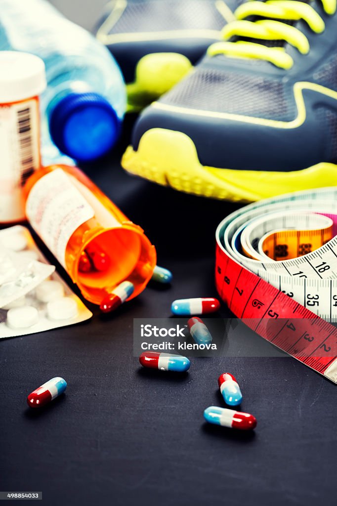 Different tools for sport and pills Different tools for sport and pills (Vitamins or Fitness Supplement) on grey background - sport, health and diet concept Anaerobic Exercise Stock Photo
