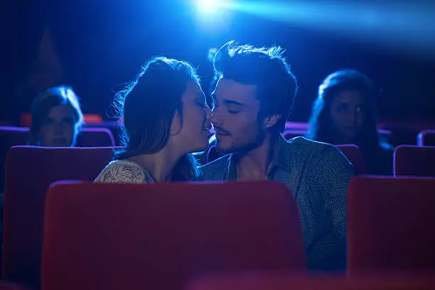 Young romantic loving couple kissing at the cinema, relationships and lifestyle concept