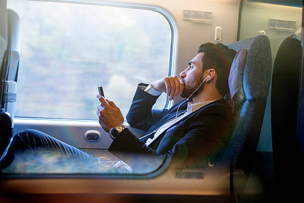 istock Bussinesman seating on a train beside window and working 498856008