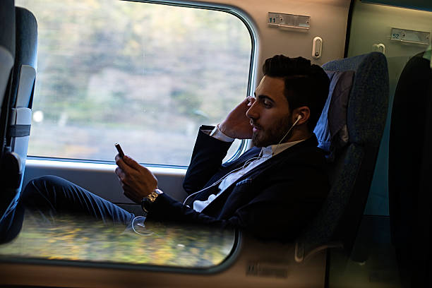 istock Bussinesman seating on a train beside window and working 498856112