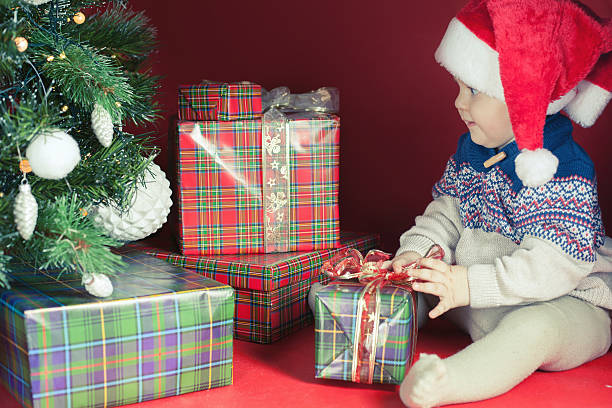 istock Happy baby with many gift box near decorated Christmas tree 498857622