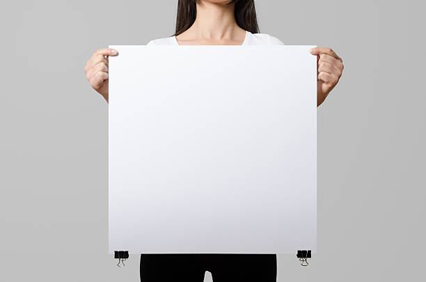 istock Woman holding a blank poster, square 50x50, mock up. 498860104