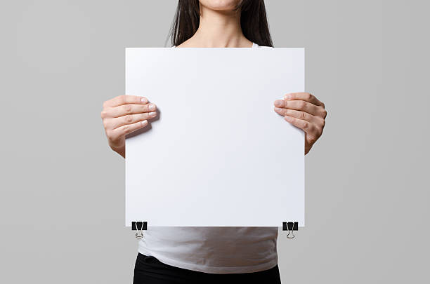 istock Woman holding a blank poster, square 35x35, mock up. 498860136