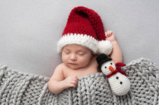 Newborn Baby Boy with Santa Hat and Snowman Plush Toy stock photo