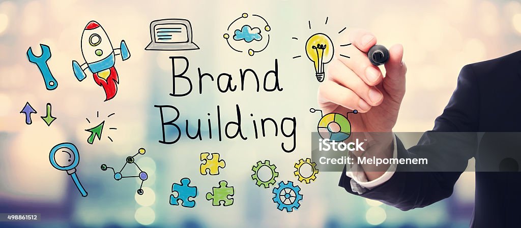 Businessman drawing Brand Building concept Businessman drawing Brand Building concept on blurred abstract background 2015 Stock Photo