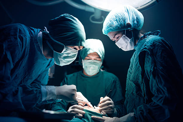 Medical team performing surgery Surgical team working on a patient in operating theater doctors surgery stock pictures, royalty-free photos & images