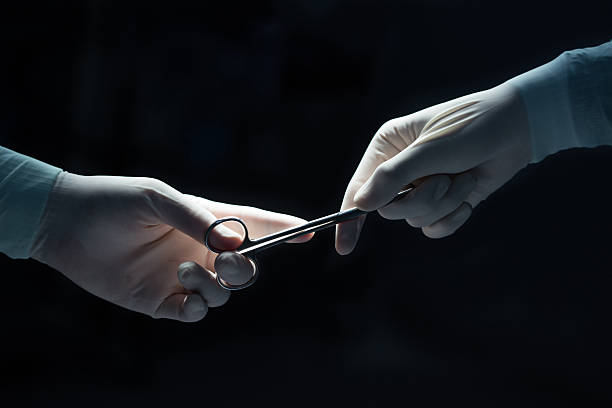 medical concept , Close-up of gloved hands passing the surgical scissors stock photo