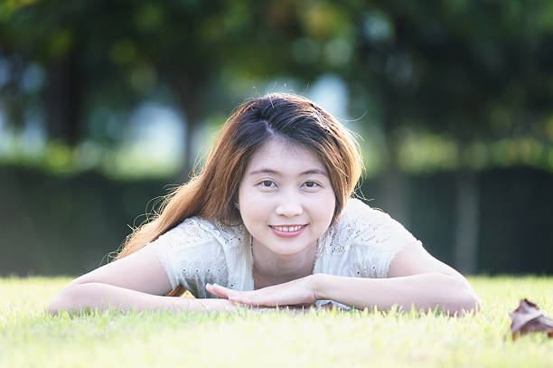 istock asia beautiful young woman lying on green grass 498861788