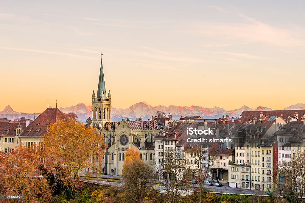 Bern in Autumn Facades of the old town of Bern, capital of Switzerland, with Swiss alps peaks in the background glowing reddish during an  autumn sunset. Bern Canton Stock Photo