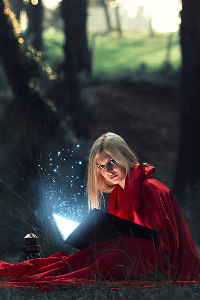 istock Beautiful blond woman reading magic book in forest 498862858