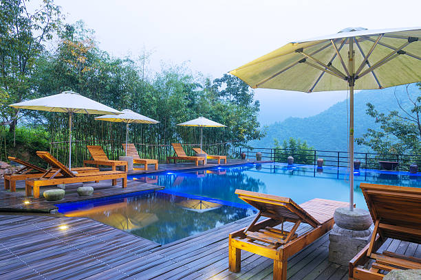 istock Umbrella chair in hotel pool resort with sunset 498863530