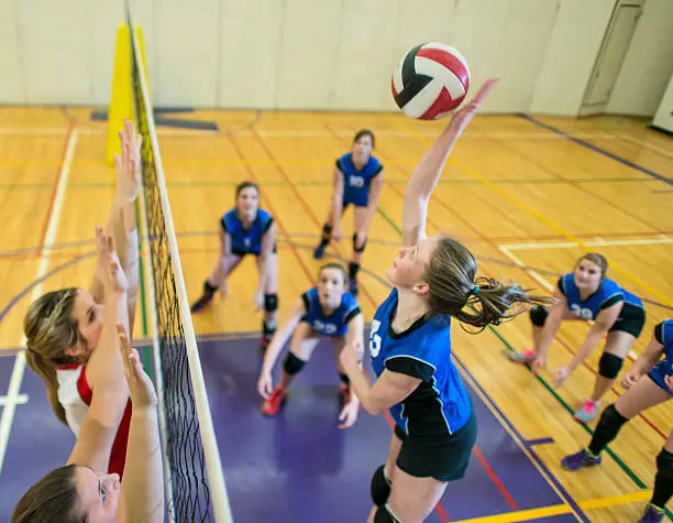 Girls having volleyball game indoor