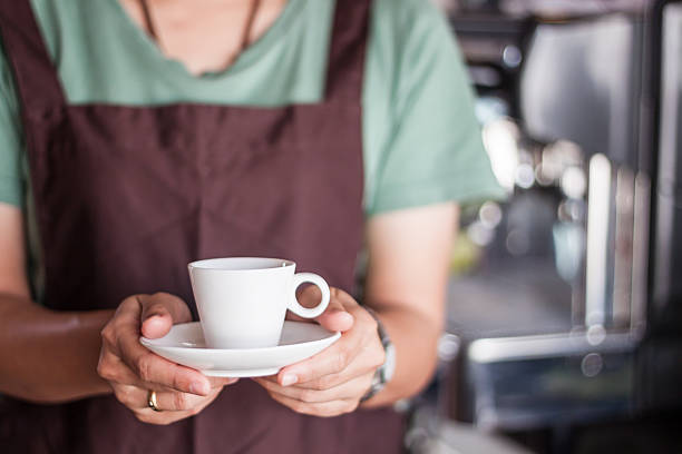 Asian barista serving freshly brewed coffee