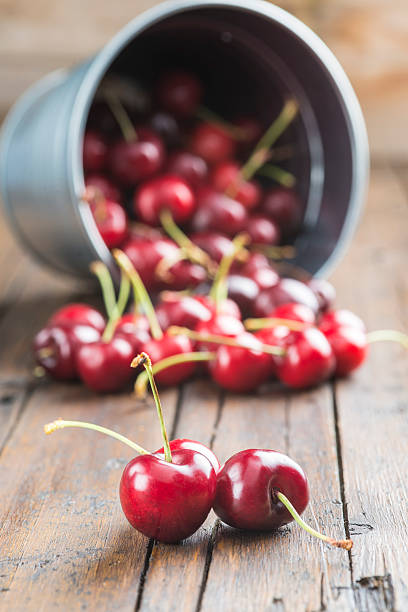 istock Little brass bucket of cherries on a table 498880361