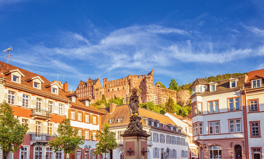 View over the corn market (Kornmarkt) with the statue of the Virgin in the center in the histor cneter of Heidelberg. The famous Heidleberg castle ruins in the distance