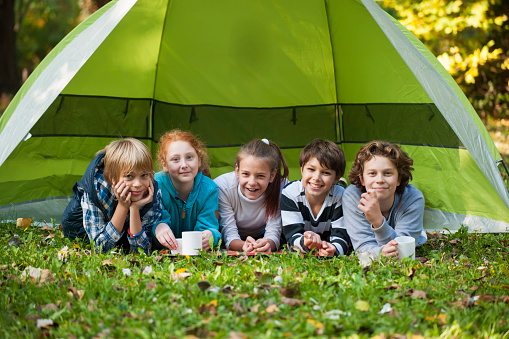 Cute children with dog  lying in their tent