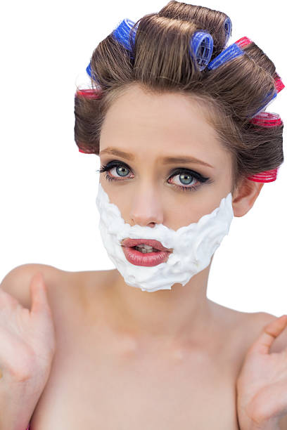 istock Surprised model in hair curlers posing with shaving foam 498883905
