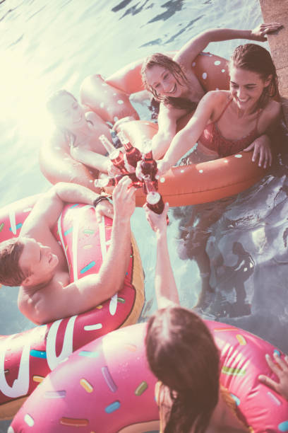 istock Friends in a pool saying cheers with colourful bottled beverages 498885154