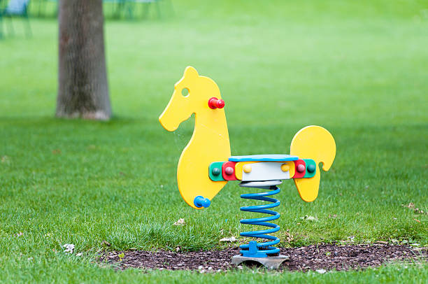 caballo de balancín en un patio de juegos - swing rocker fotografías e imágenes de stock