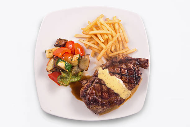 Grilled Steak served with Hollandaise sauce, fries, and sauteed vegetable Grilled Steak served with Hollandaise sauce, fries, and stir fry / sauteed vegetable hollandaise sauce stock pictures, royalty-free photos & images