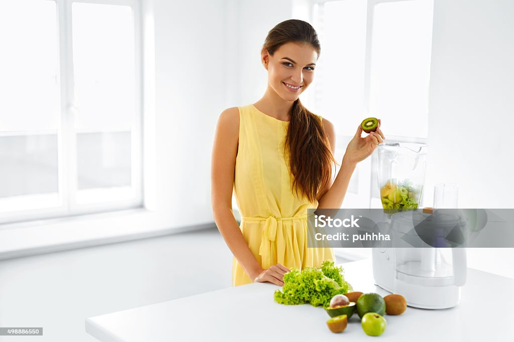 Healthy Nutrition. Woman With Detox Smoothie Juice. Diet Meal Eating Healthy Nutrition. Closeup Of Smiling Young Woman With Blender Chopping Vegetables For Green Detox Raw Smoothie Juice. Healthy Diet Meal Eating. Vegetarian Food, Dieting. 2015 Stock Photo