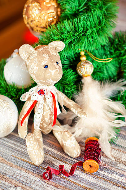 istock Christmas gift tilda Teddy bear toy sitting on festive background 498887938