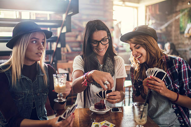 istock Young smiling friends playing cards in a cafe. 498890520