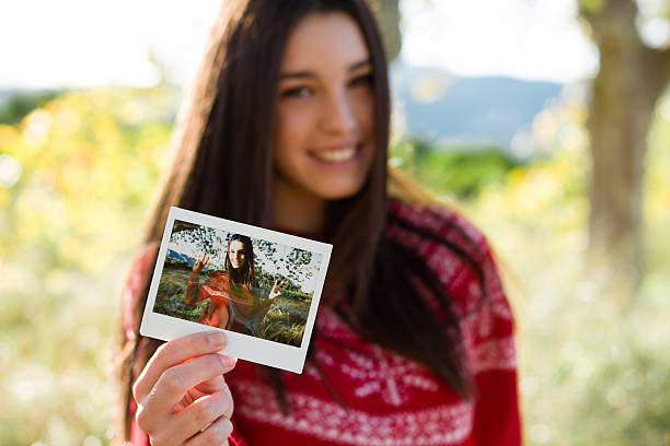 giovane donna con una foto istantanea - instant print transfer foto e immagini stock