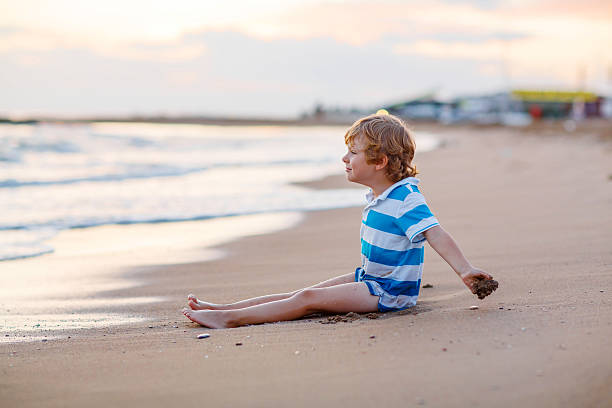 istock little kid boy having fun with sand castle by ocean 498891976