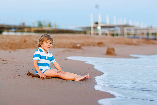 istock little kid boy having fun with sand castle by ocean 498892530