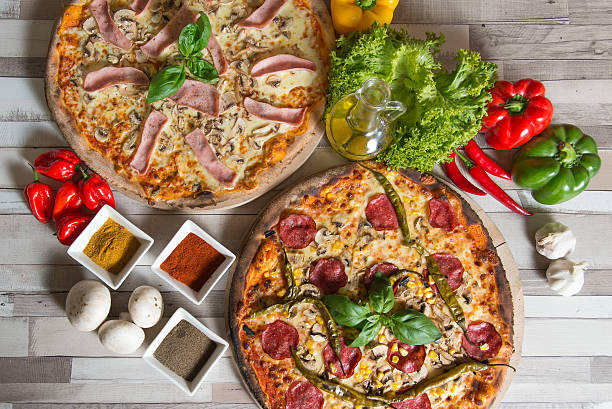 istock Composition with two pizzas and ingredients at wooden background 498892698