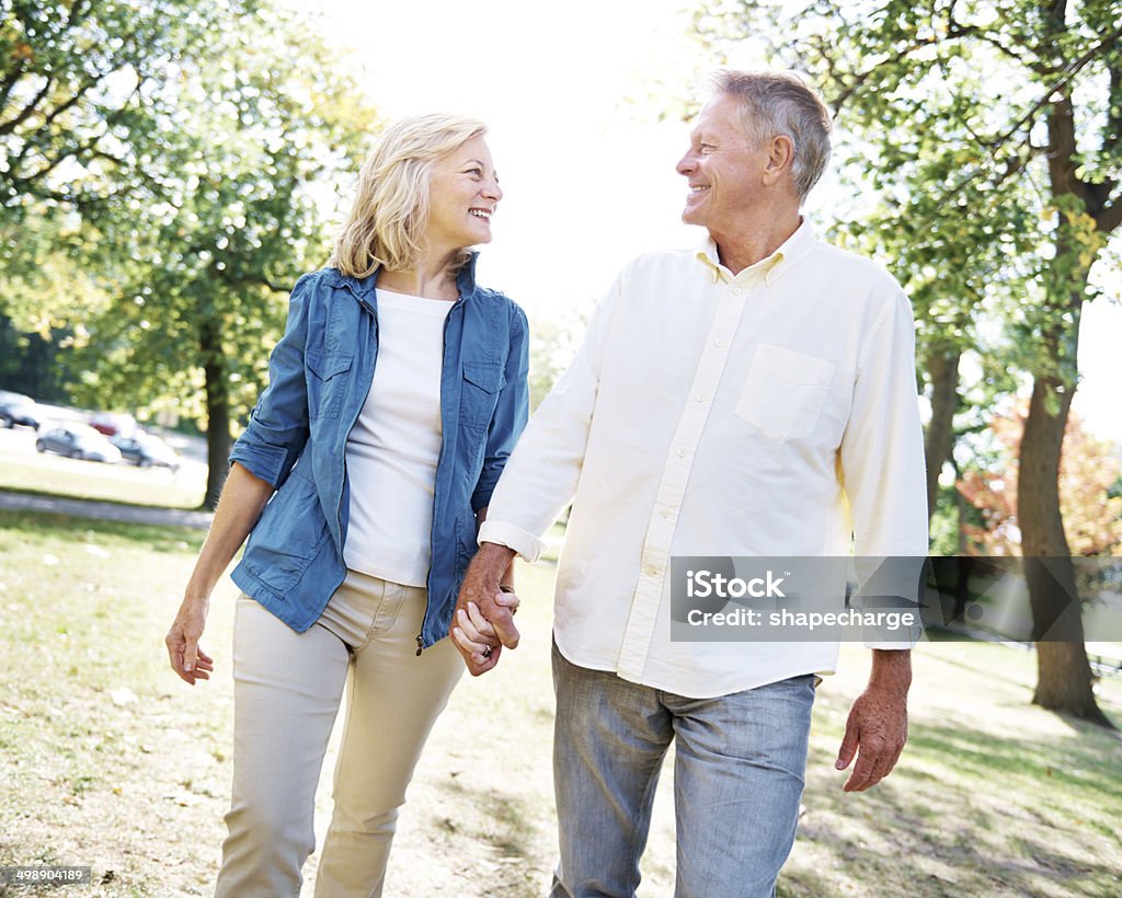 Active and happy Shot of an affectionate senior couple enjoying a walk in the park 60-69 Years Stock Photo