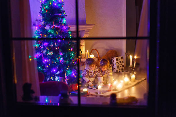 istock Two little boys sitting by fireplace at home on Christmas 498908984