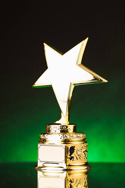 istock gold star trophy against green background 498910252