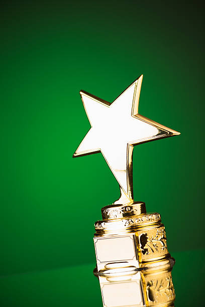 istock gold star trophy on green background 498910448