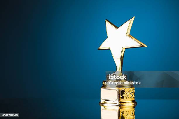 Gold Star Trophy Against Blue Background Stock Photo - Download Image Now - Award, Trophy - Award, Star Shape