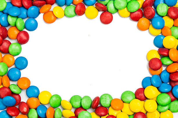 istock Frame of colorful chocolate candy on white background with space 498911766