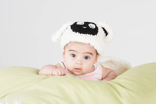 istock Goergous curious baby posing on pillow with lamb beret costume 498914876