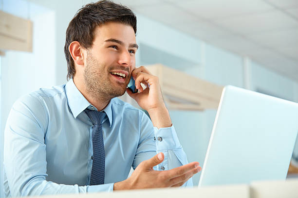 istock Smiling business man talking on mobile phone in a office 498916354