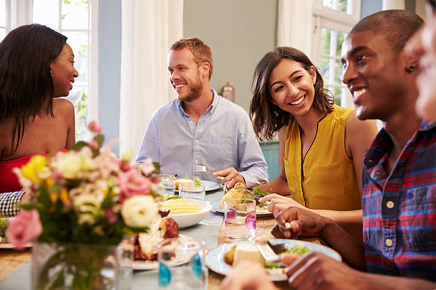 istock Friends At Home Sitting Around Table For Dinner Party 498919060