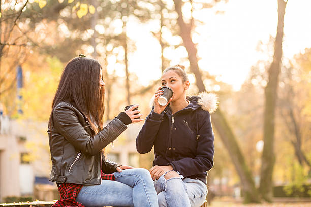 istock Two friends drinking coffee at the park 498920558