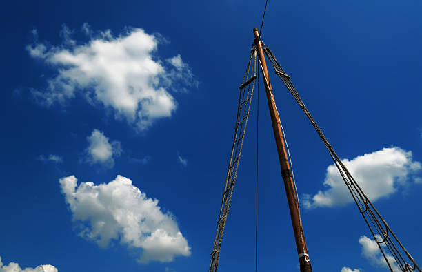 Wooden mast sailing ship against the cloudy sky