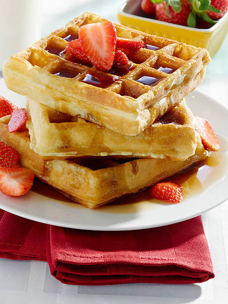 istock breakfast - waffles with syrup and strawberries 498926383
