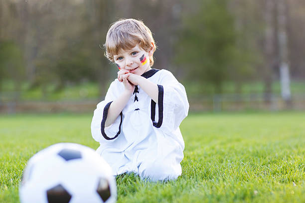 kleinen ventilator junge im öffentlichen anzeige des fußball-spiel - playing field goalie soccer player little boys stock-fotos und bilder